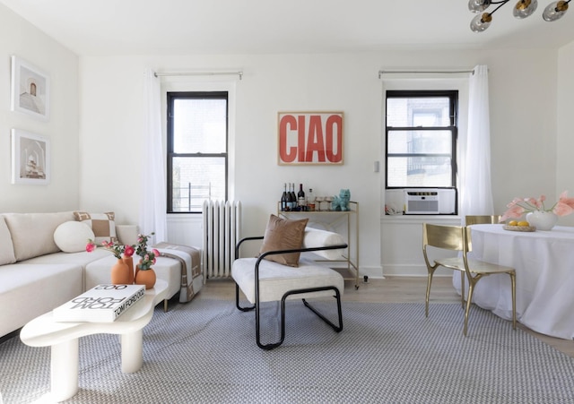21-67 33rd St Unit 5-H, New York City, NY 11105 - living room featuring radiator, wood finished floors, and cooling unit