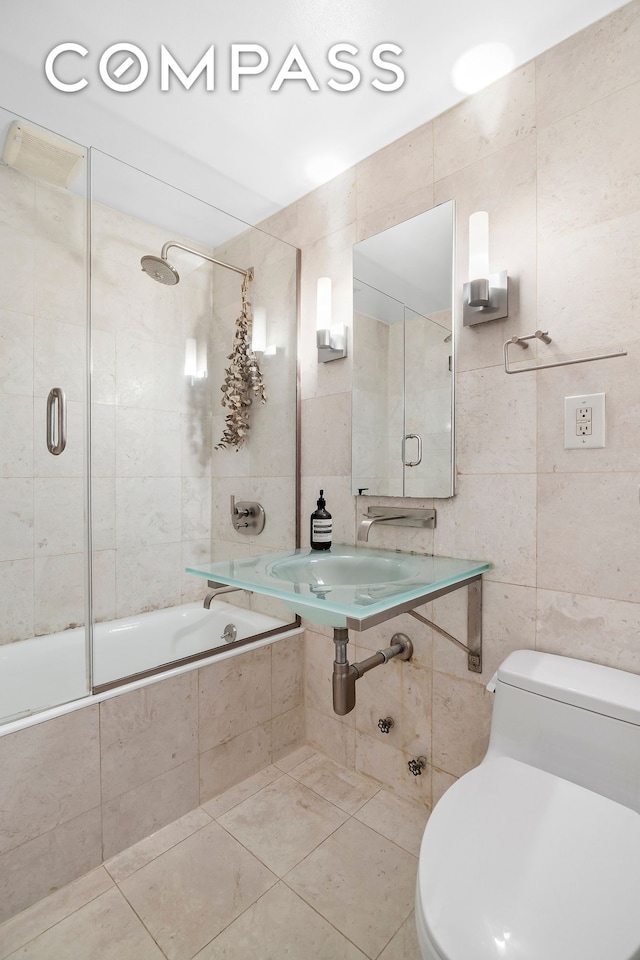full bath featuring tile walls, tiled shower / bath combo, tile patterned floors, and toilet