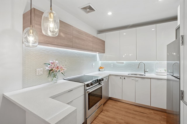 1059 Manhattan Ave Unit 2D, New York City, NY 11222 - kitchen with stainless steel appliances, modern cabinets, backsplash, and light wood-type flooring