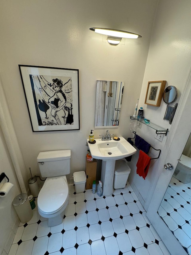half bath featuring toilet, tile patterned floors, and baseboards