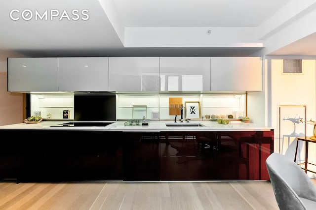 135 W 52nd St Unit 40A, New York City, NY 10019 - kitchen with light wood-style flooring, black electric cooktop, light countertops, and modern cabinets