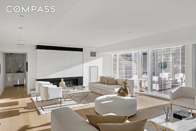 135 W 52nd St Unit 40A, New York City, NY 10019 - living room featuring light wood finished floors and a glass covered fireplace