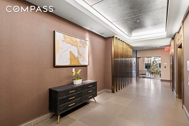 135 W 52nd St Unit 40A, New York City, NY 10019 - hallway featuring a tray ceiling and light tile patterned floors