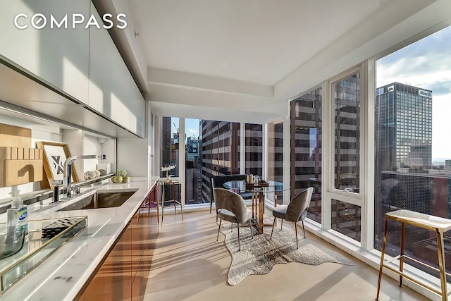 135 W 52nd St Unit 40A, New York City, NY 10019 - sunroom featuring a city view, floor to ceiling windows, and wood finished floors