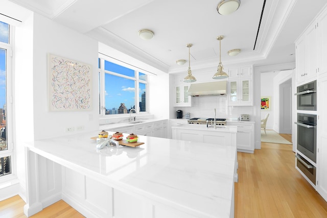 kitchen with glass insert cabinets, a warming drawer, a sink, ventilation hood, and a peninsula