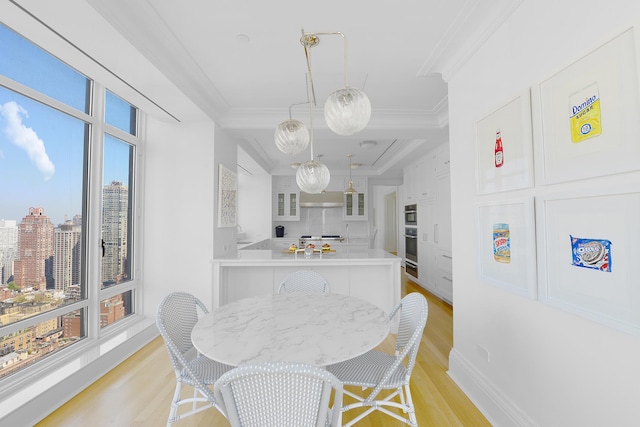 dining room with light wood-type flooring and ornamental molding