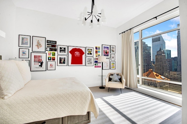 bedroom featuring an inviting chandelier, a city view, and baseboards
