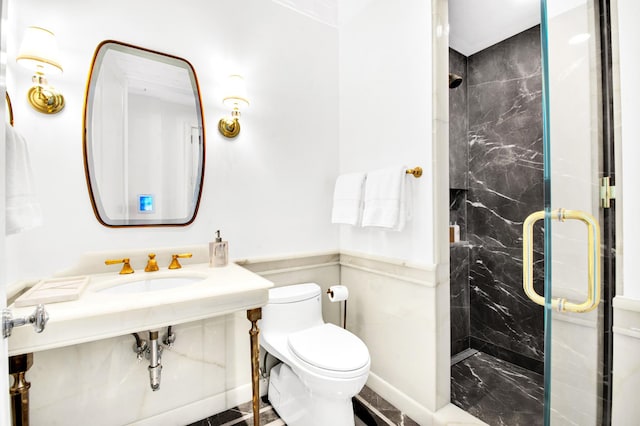 bathroom featuring a sink, toilet, and a marble finish shower