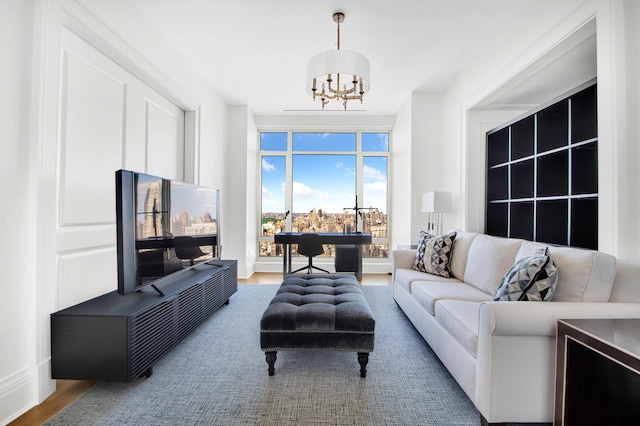 living area featuring a chandelier, baseboards, and wood finished floors