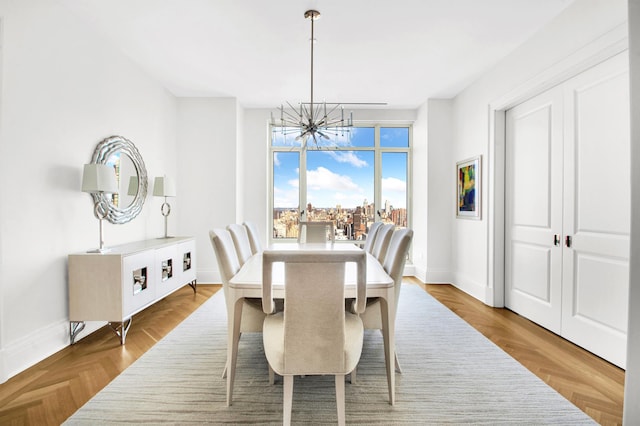 dining room with a chandelier and baseboards
