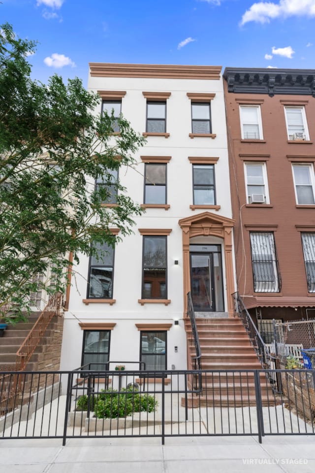 view of front of house featuring fence and stairs