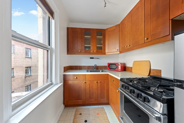 70 Remsen St Unit 9E, New York City, NY 11201 - kitchen featuring stainless steel appliances, a sink, brown cabinets, and light countertops