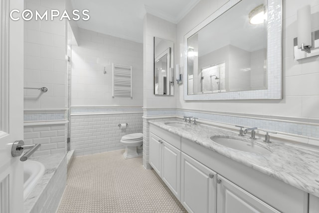 full bathroom featuring tile walls, ornamental molding, toilet, double vanity, and tiled shower