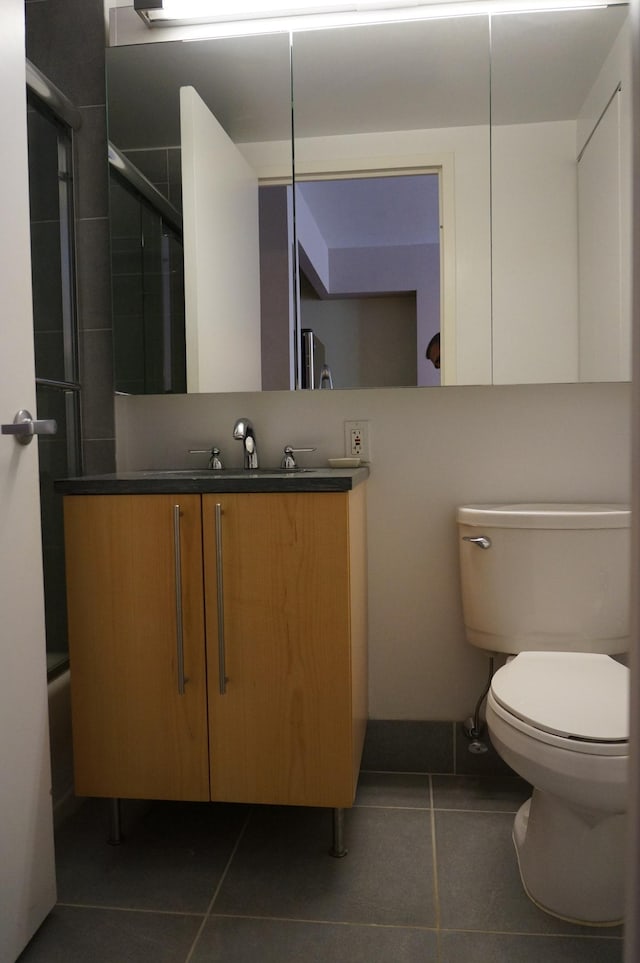 full bath with toilet, a shower with shower door, tile patterned floors, and vanity