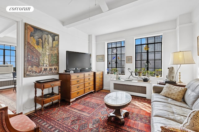 25 Tudor City Pl Unit 1812, New York City, NY 10017 - living room featuring radiator heating unit, beamed ceiling, wood finished floors, a ceiling fan, and baseboards