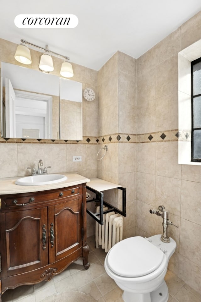 25 Tudor City Pl Unit 1812, New York City, NY 10017 - bathroom featuring radiator heating unit, tile walls, vanity, tile patterned flooring, and backsplash