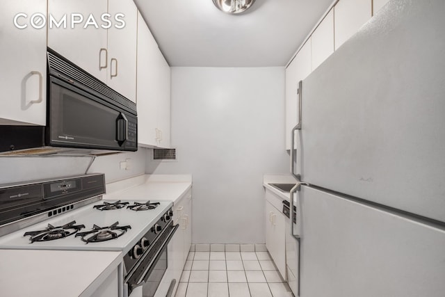 301 E 64th St Unit 4J, New York City, NY 10065 - kitchen featuring white appliances, white cabinets, light countertops, and light tile patterned floors