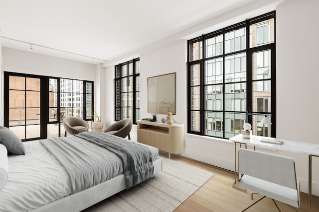 517 W 29th St Phc, Phc, New York City, NY 10001 - bedroom featuring light wood-style flooring, multiple windows, and rail lighting