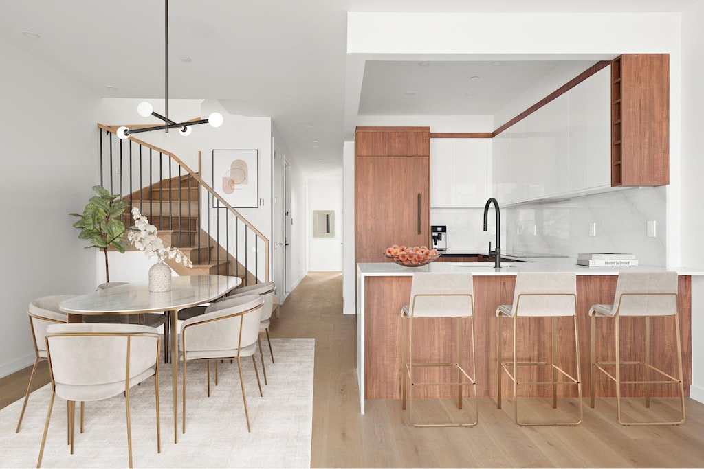 kitchen with brown cabinetry, light countertops, a sink, light wood-type flooring, and modern cabinets