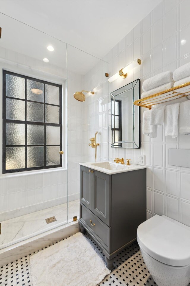 465 Park Ave Unit 18F, New York City, NY 10022 - full bath featuring a stall shower, tile walls, vanity, and toilet