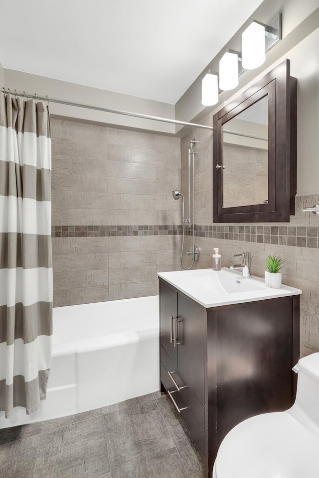 bathroom with toilet, tile walls, shower / tub combo with curtain, and vanity