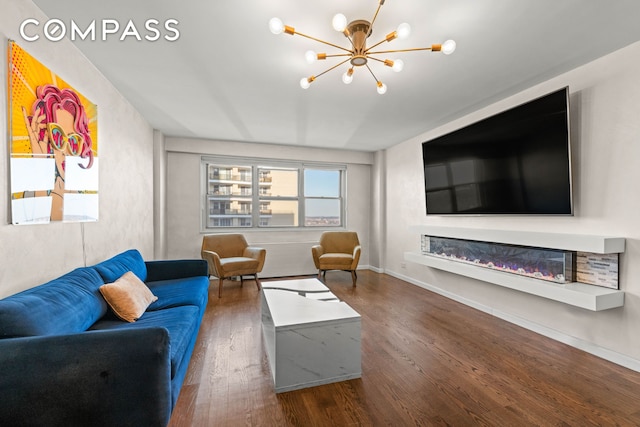 102-10 66th Rd Unit K25, New York City, NY 11375 - living room with baseboards, a glass covered fireplace, a chandelier, and dark wood-style floors