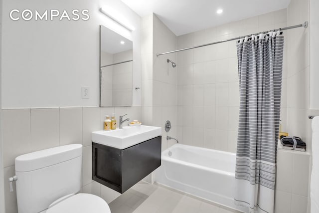 bathroom featuring vanity, toilet, tile walls, shower / bathtub combination with curtain, and recessed lighting