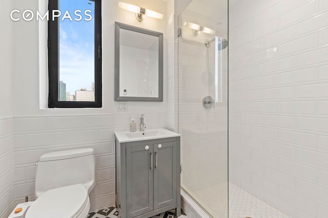 bathroom with a walk in shower, toilet, tile walls, and vanity