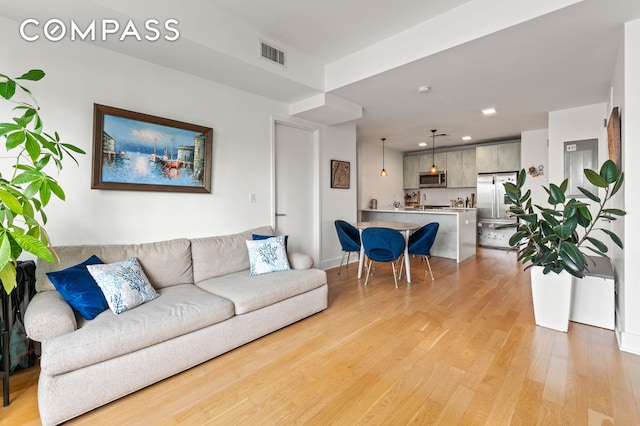 living area with visible vents, recessed lighting, and light wood finished floors