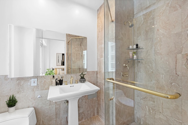 full bathroom with tile walls, toilet, and a shower stall