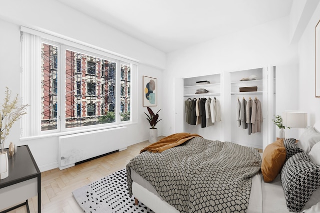 bedroom featuring radiator heating unit, multiple windows, and a closet