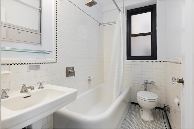 235 E 22nd St Unit 6P, New York City, NY 10010 - bathroom with tile walls, shower / tub combo with curtain, tile patterned floors, and a wainscoted wall