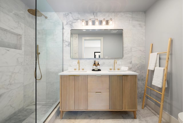 bathroom featuring tile walls, a marble finish shower, and a sink