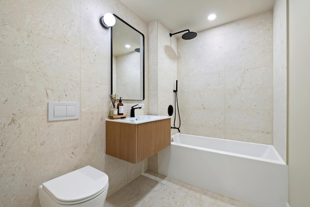 bathroom featuring vanity, toilet, bathing tub / shower combination, and tile walls