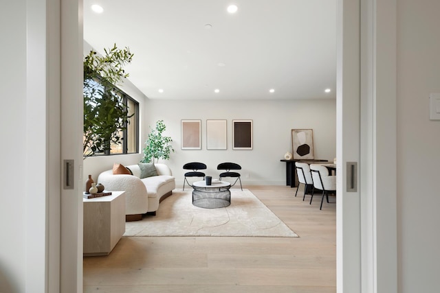 living area with recessed lighting, baseboards, and light wood-style flooring