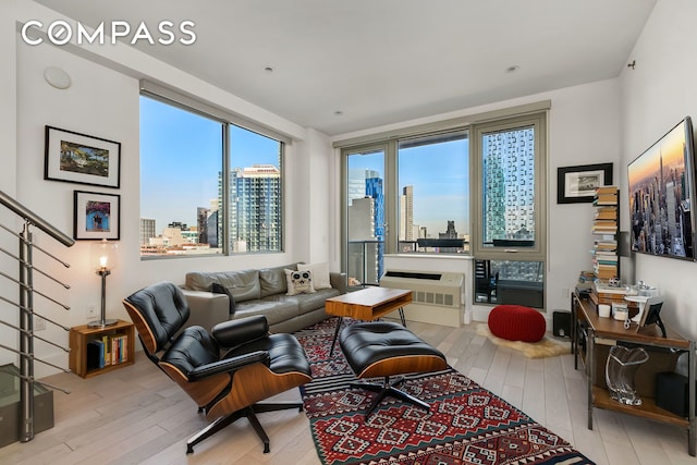 living area featuring stairway, a view of city, and wood finished floors