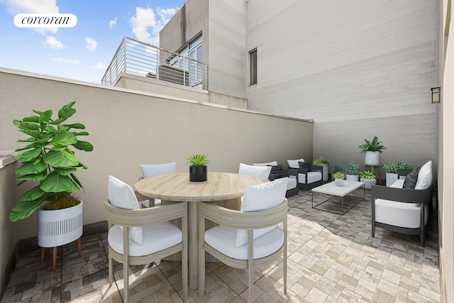 view of patio with outdoor dining area, outdoor lounge area, and a balcony