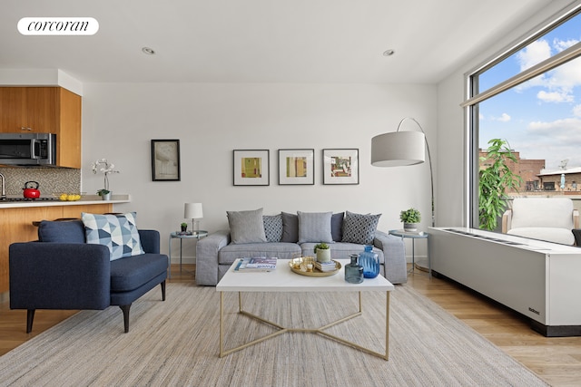 living area with recessed lighting and light wood finished floors