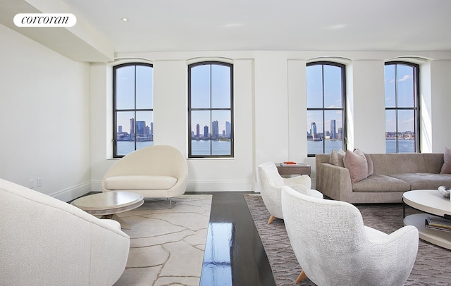 living room with dark wood-type flooring, visible vents, a city view, and baseboards