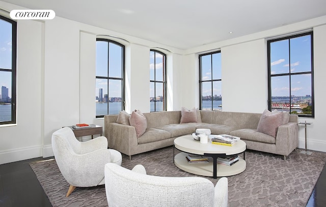 living room with a view of city, a water view, and baseboards