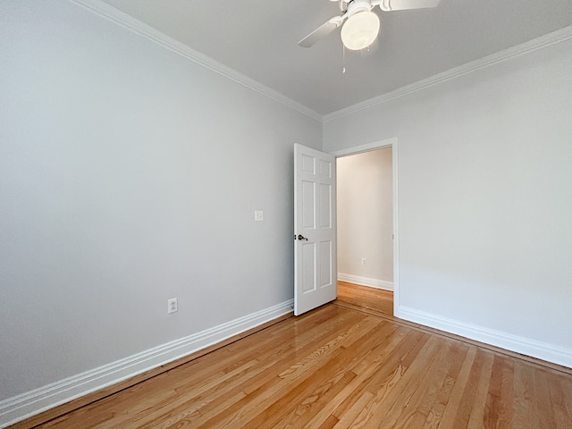 empty room featuring baseboards, ornamental molding, a ceiling fan, and light wood finished floors