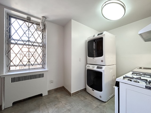 laundry room featuring stacked washer and dryer, baseboards, and radiator heating unit