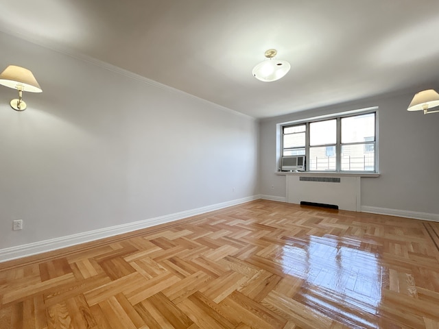 spare room with baseboards, ornamental molding, radiator, and cooling unit