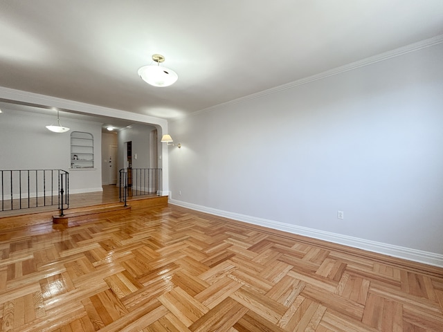 spare room with crown molding and baseboards