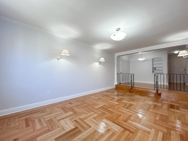 spare room featuring baseboards and ornamental molding