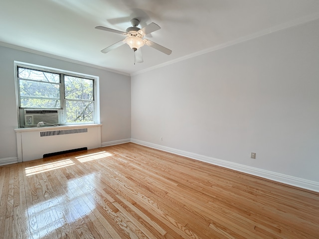 unfurnished room with crown molding, ceiling fan, radiator, baseboards, and wood finished floors