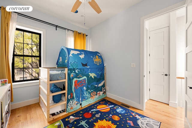 bedroom featuring light wood-style floors, baseboards, and multiple windows