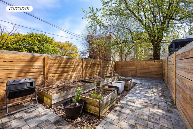 view of patio / terrace featuring a fenced backyard and a garden