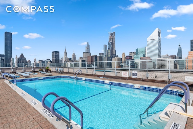 community pool featuring a view of city and fence