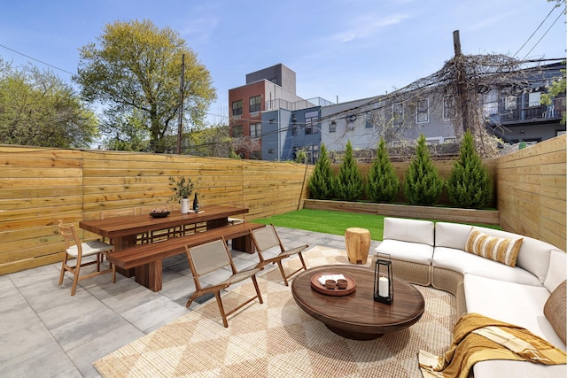 view of patio featuring outdoor dining area, a fenced backyard, and an outdoor hangout area